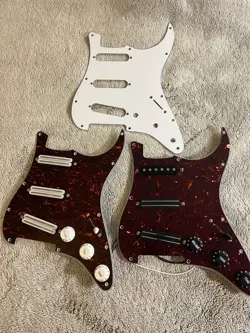 LOT OF TWO LOADED FENDER STRATOCASTER PICKGUARDS AND EXTRAS. 11 HOLE RAILS