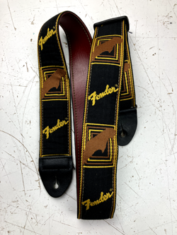 USED VTG FENDER MONOGRAMMED GUITAR STRAP (BLACK/YELL/BROWN) W. RED BACK